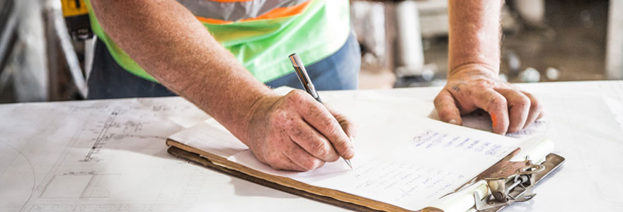 Une homme faisant une liste de tâches à réaliser pour son chantier.